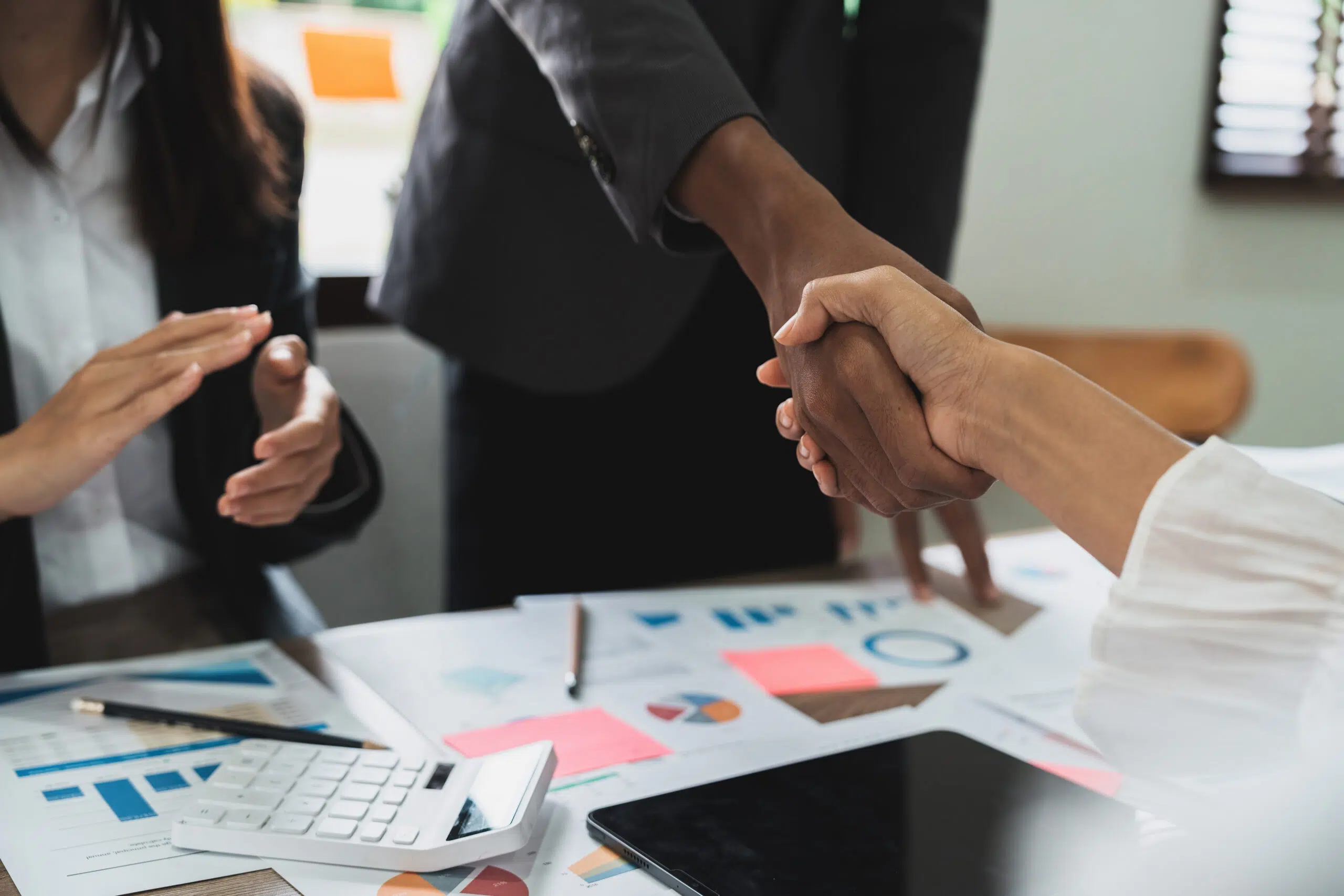 Group business people handshake at meeting table in office together with confident shot from top view . Young businessman and businesswoman workers express agreement of investment deal