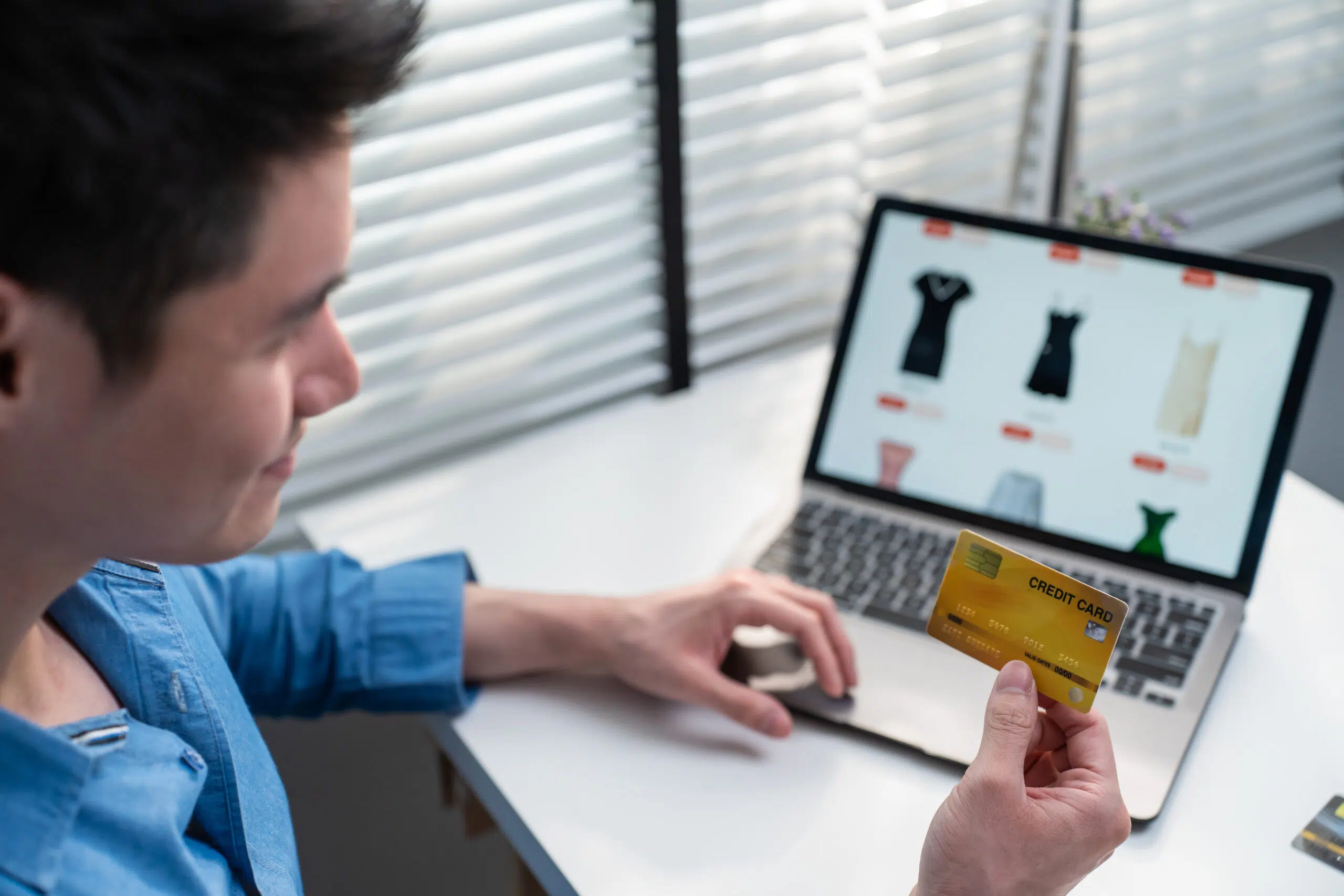 Asian active man use laptop computer for shopping product sell online. Attractive handsome male holding credit card in hands to buying and purchase goods on website in smartphone. E-commerce concept.