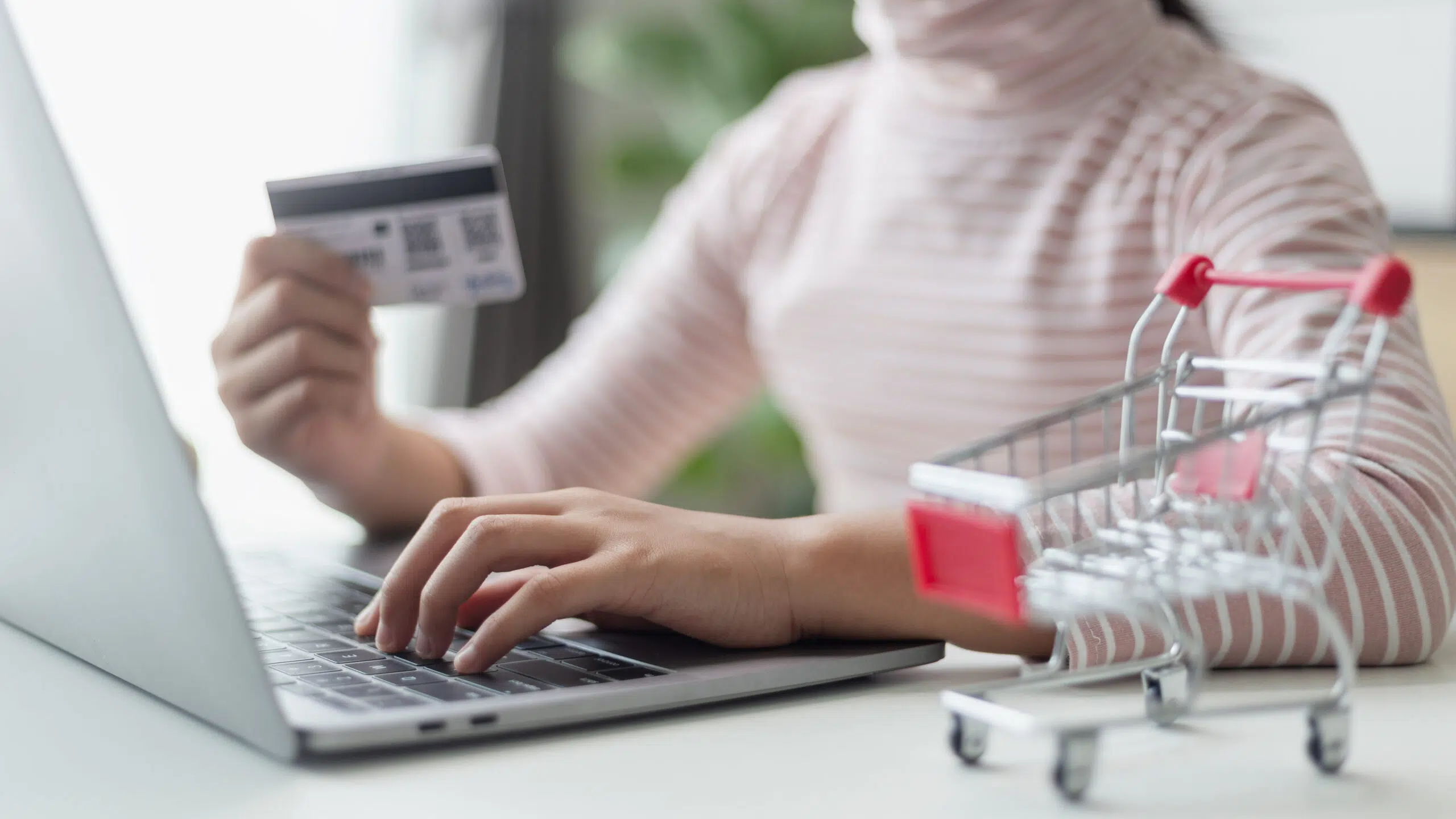 Hands holding credit cards and using a laptop. Online shopping and online payment concepts.